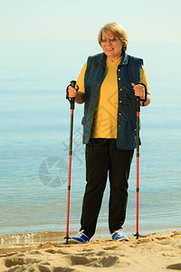 活跃的成熟生方式老年卫士在沙滩海岸上行走图片