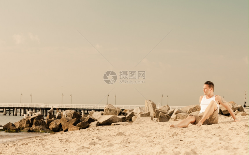 快乐暑假和人的概念时装肖像长满沙滩风景的英俊男子图片