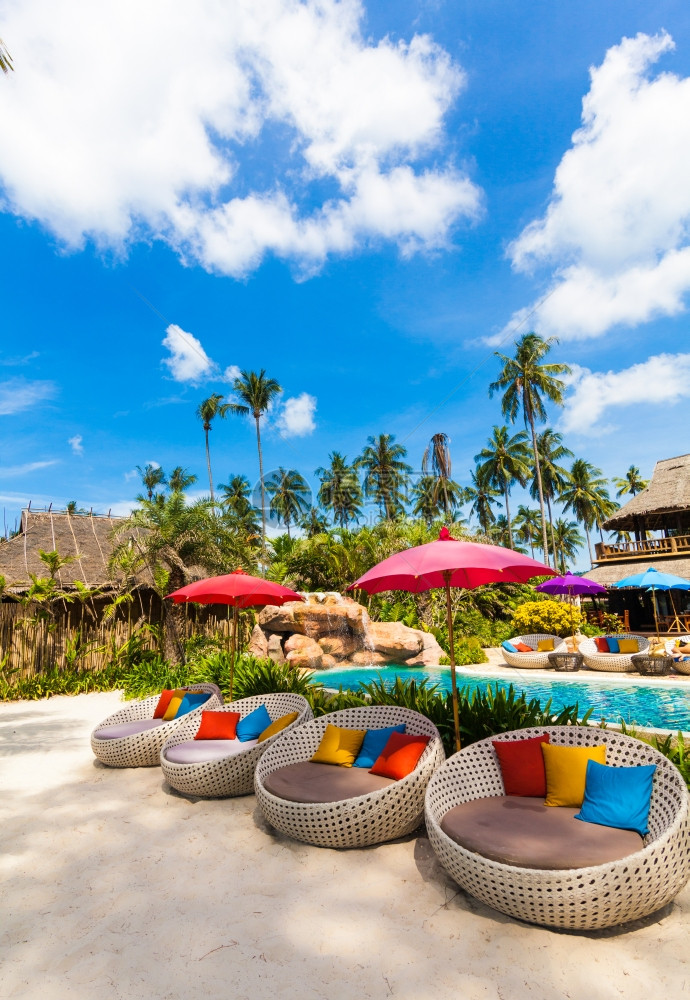 热带海岸的太阳雨伞和沙椅图片