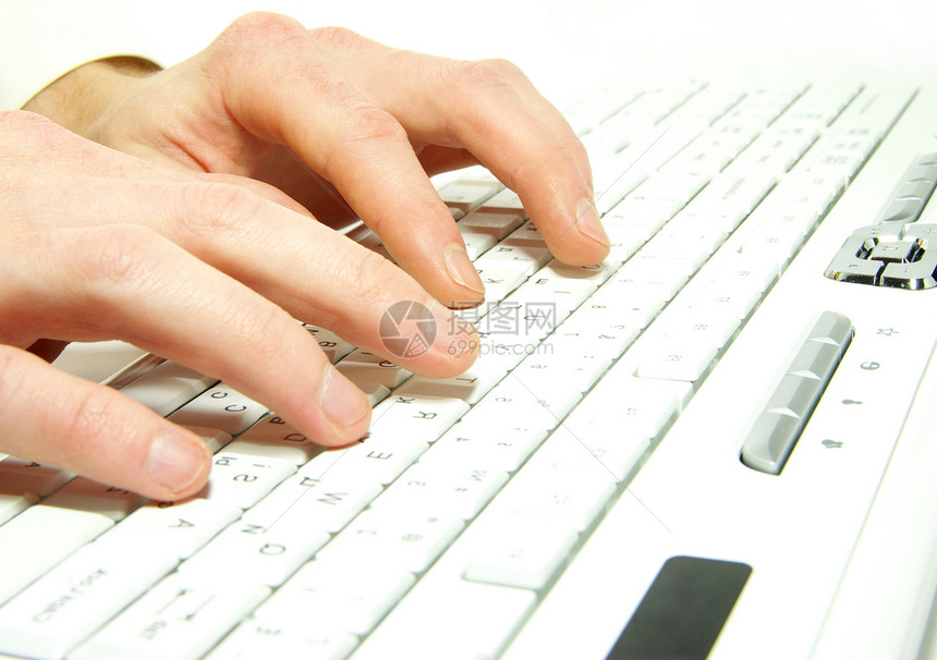 男手在白色计算机键盘上打字图片