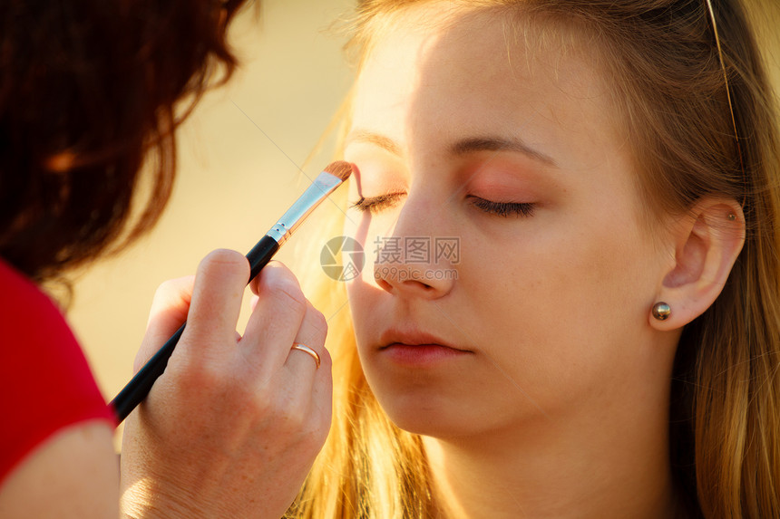 化妆美容程序和概念师在女眼睛上应用刷子色的眼线图片