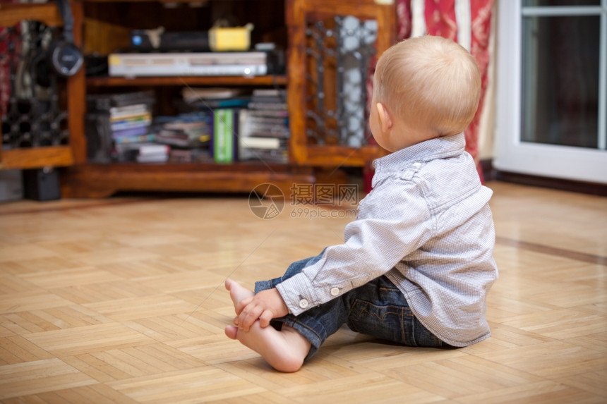 快乐的童年坐在地板上的所有小男孩的背部室内家里图片