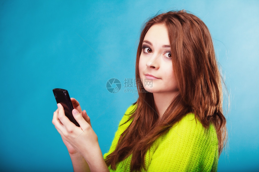 技术和通信少女在手机上发短信使用智能手机阅读蓝字短语图片