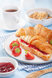 面包和草莓加果酱和草莓的新鲜羊角面包早餐用背景