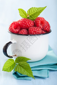 蓝底咖啡杯中的新鲜草莓图片