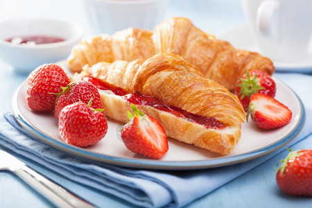 加果酱和草莓的新鲜羊角面包早餐图片