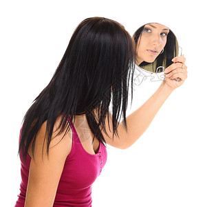 青春的女人棕发看着镜子孤立在白色背景图片
