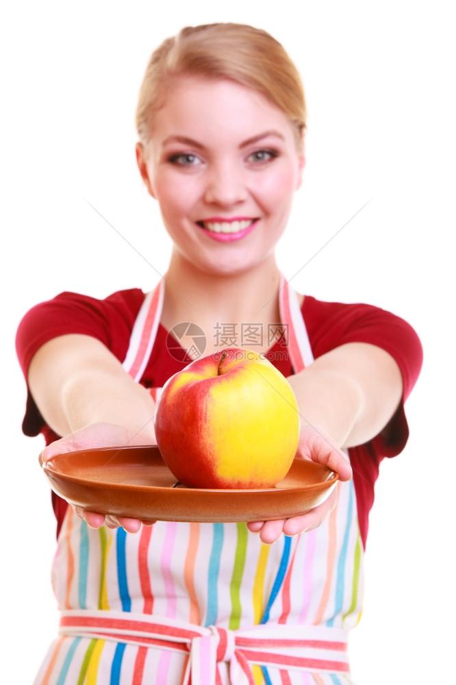 快乐的家庭主妇或厨师在丰富多彩的厨房里展示红黄苹果健康水孤立的摄影棚拍饮食和营养图片