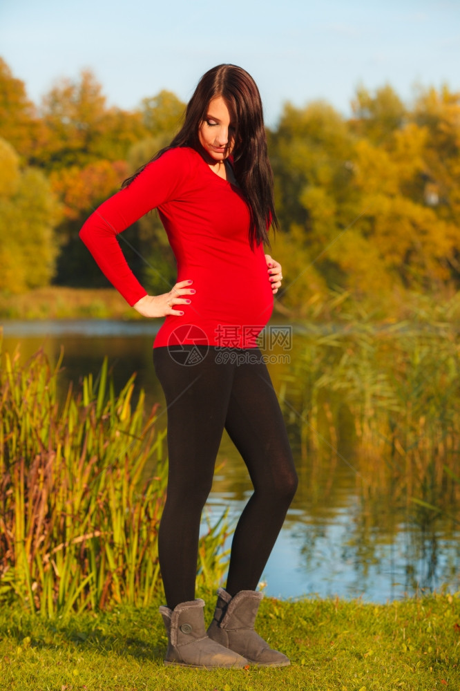 怀孕母亲和幸福概念放松的平静孕妇在秋季公园外散步图片