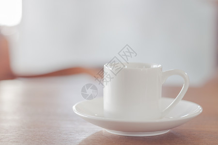 木制桌上的小型白咖啡杯股票照片背景图片
