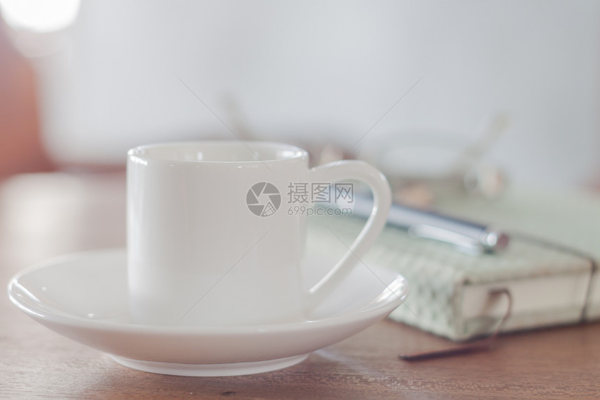 带有笔记本库存照片的小型白色咖啡杯图片