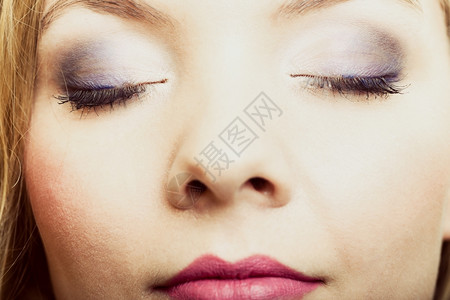 美女双眼的近相蓝色紫的化妆品将涂在眼睛上图片