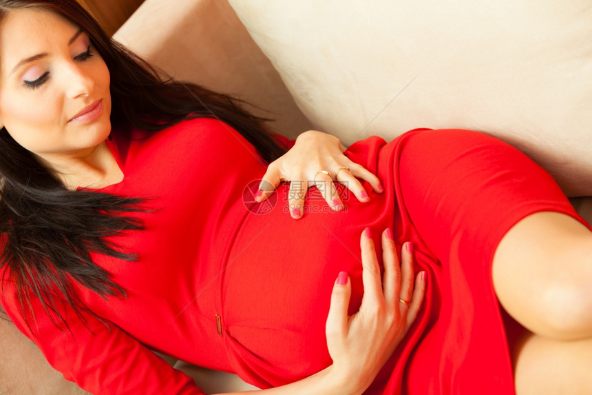 孕妇在沙发上放松摸她的肚子图片