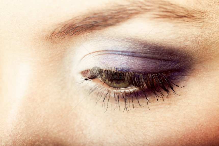美女眼睛的紧贴部分蓝色紫的化妆品将涂在眼睛上图片
