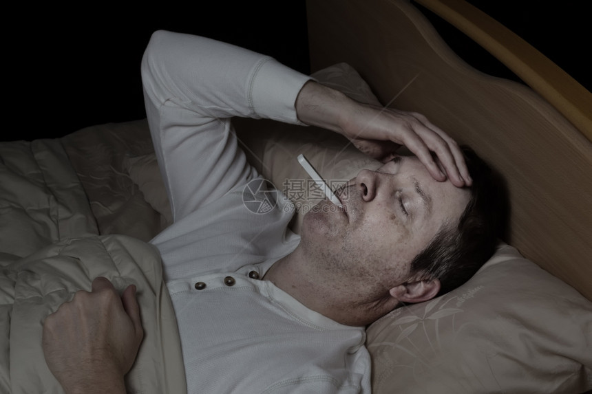 成年男子的横向形象高发躺在床上测试体温图片