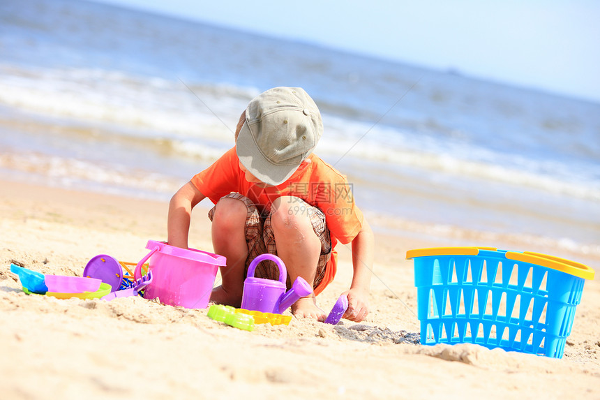 小男孩在海滩背景上玩具图片
