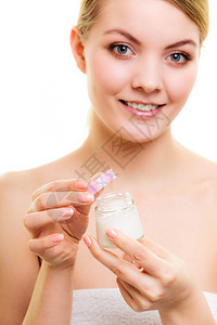 乳液水罐的年轻女金发孩照顾干燥的皮肤使用湿润的乳霜隔离图片