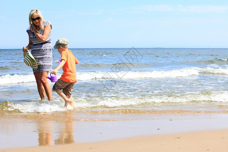 母亲和儿子在海滩玩耍图片