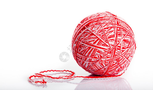 在白色背景上被孤立的红羊毛线球图片
