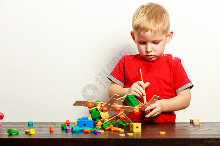 男孩儿在室内玩多姿彩的建筑玩具游戏背景图片