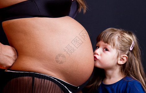 黑人背景孕妇的亲吻腹部图片
