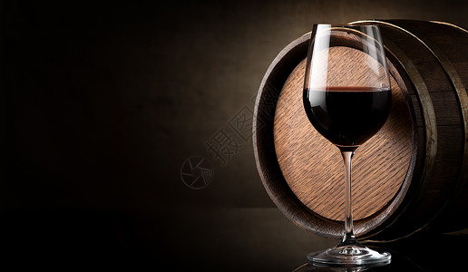 红葡萄酒和棕色背景的桶子酒杯高清图片