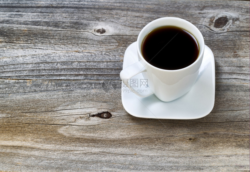 白色咖啡杯里最接近的新鲜黑咖啡配有木质本底的碟子图片
