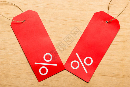 促销红色优惠券购物和销售概念红价标签在木表面背景上标有百分数符号背景