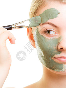 皮肤衣皮肤护理女在面部被孤立时用刷泥蒙面女孩照顾干衣美容治疗背景