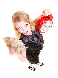 幸运的女商人持有红色闹钟和抛光货币钞票投资或储蓄的金时间图片