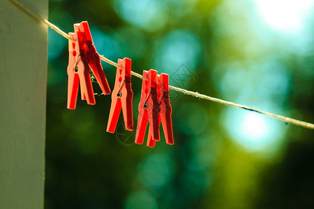 在户外的绳子上洗衣的红色夹子家务概念图片