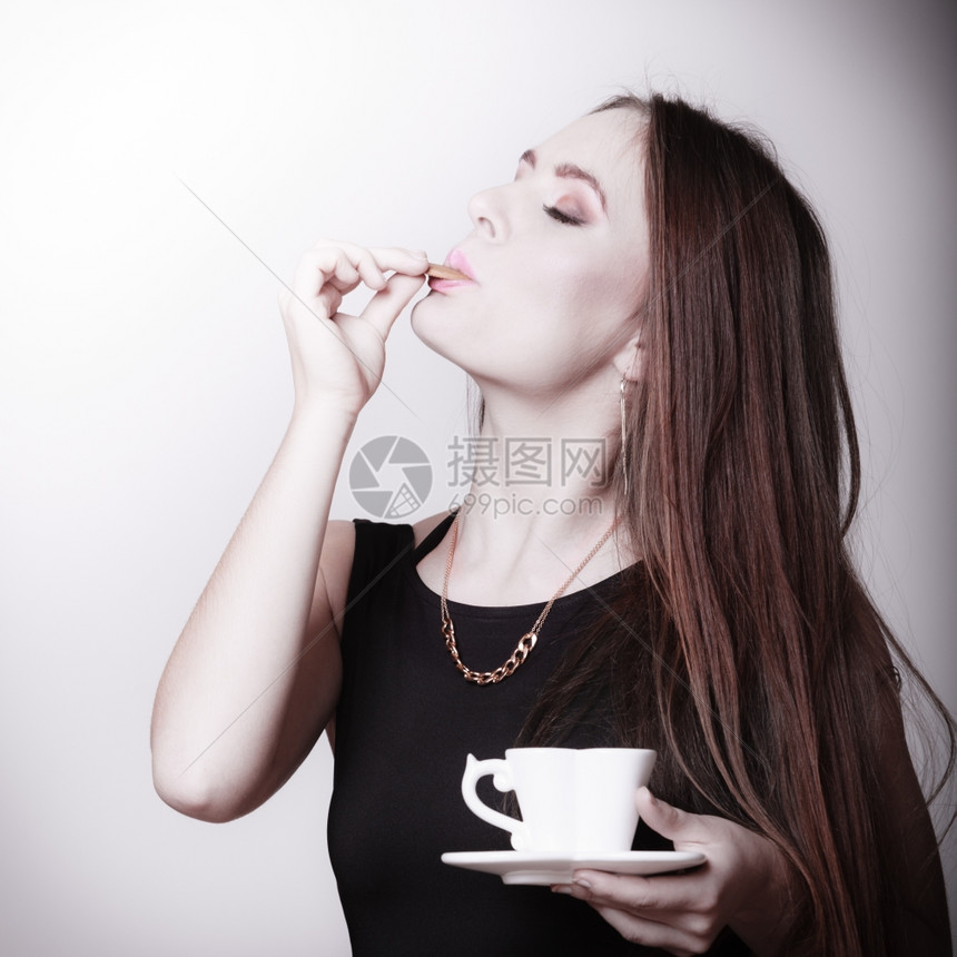美丽的感女孩拿着一杯咖啡喝灰色的饼干图片