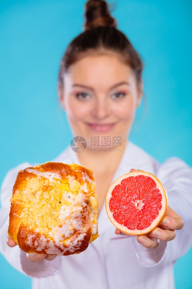 做出正确的饮食选择概念比较饮食选择的营养主义者持有蛋糕甜食和蓝葡萄油图片