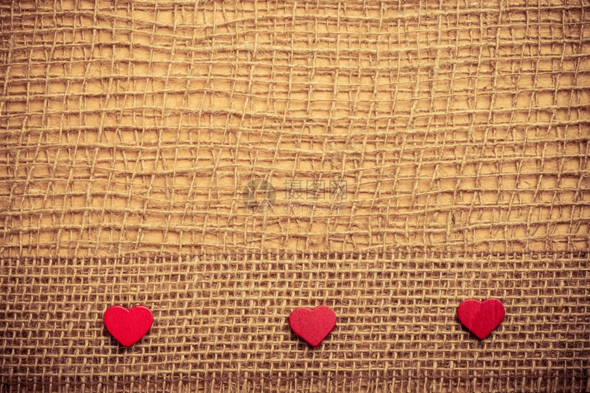 红色木质装饰心脏带在抽象布上带复制空间的薄布背景上图片