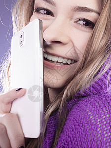 利用紫外线智能手机将年轻微笑的少女孩用手机蒙上脸部图片