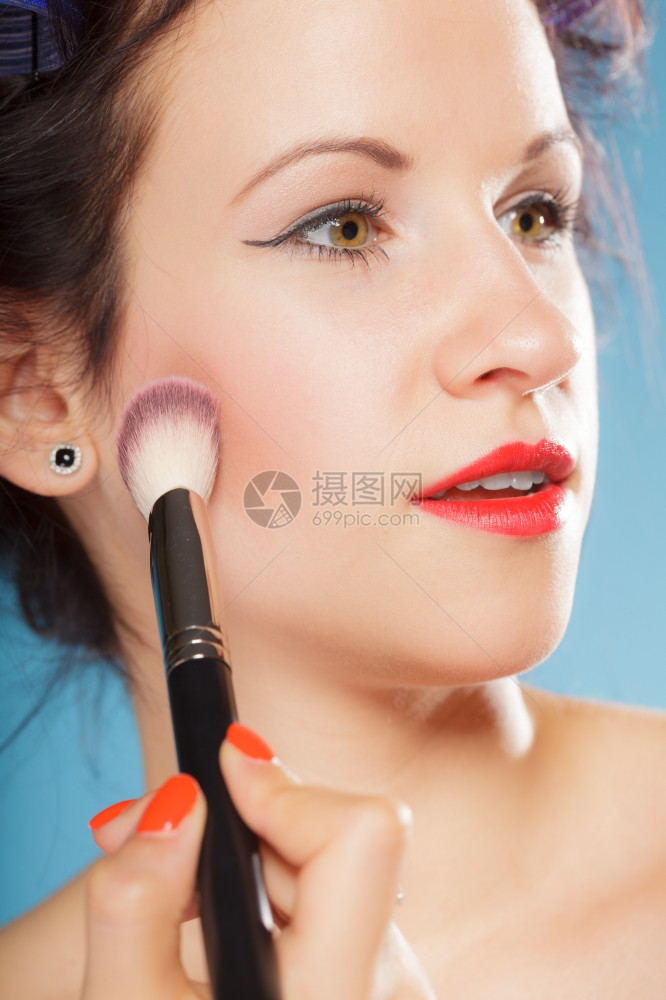 化妆美容程序和概念发卷的妇女用刷子化妆脸红女孩图片