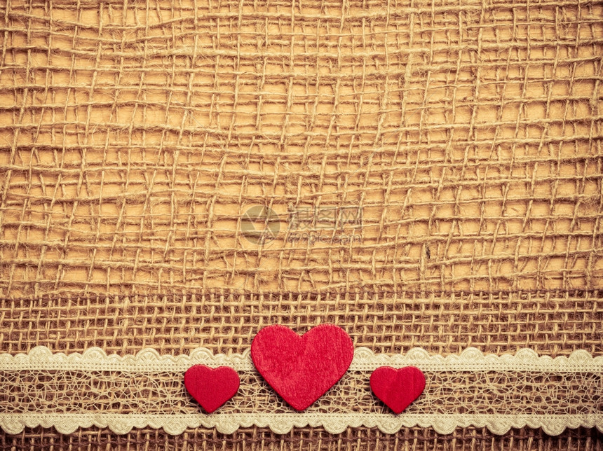 红色木制装饰心带放在抽象布上带复制空间的薄布背景图片
