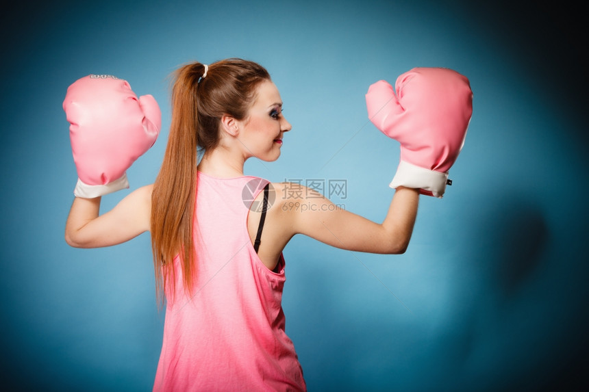 穿着粉红色大手套玩运动拳击工作室拍蓝底图片
