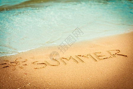 度假概念夏日这个词写在沙滩上的子背景图片