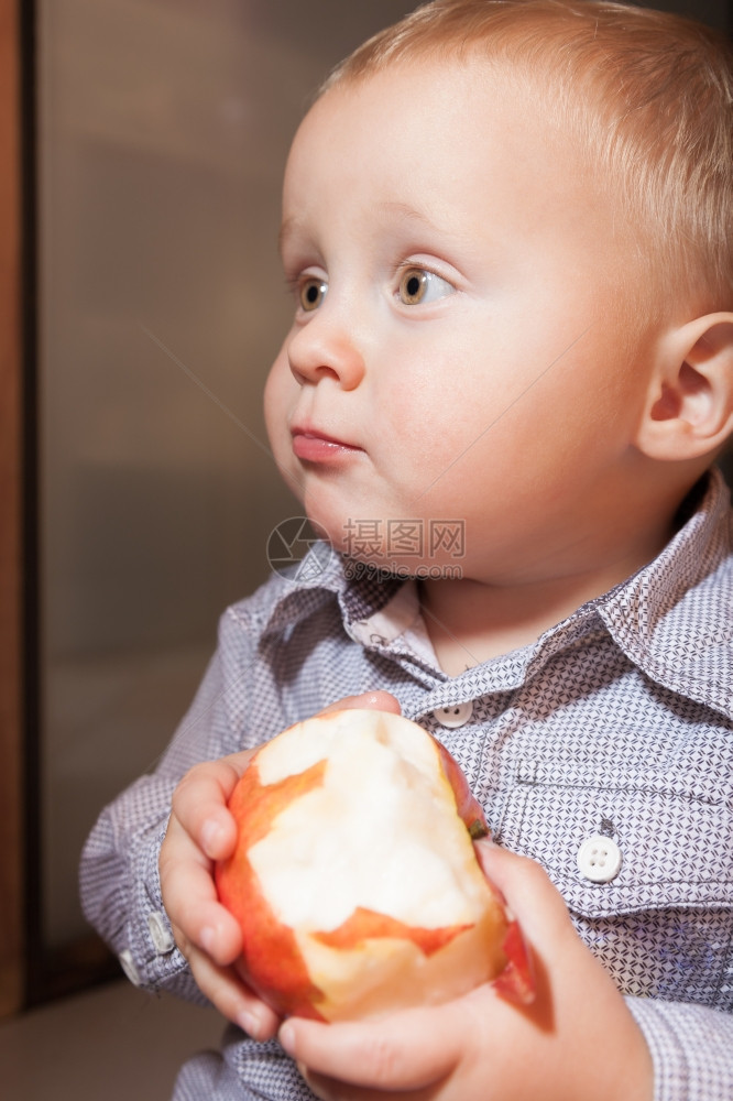 快乐的童年可爱小男孩肖像在家里吃苹果水健康的饮食和营养图片