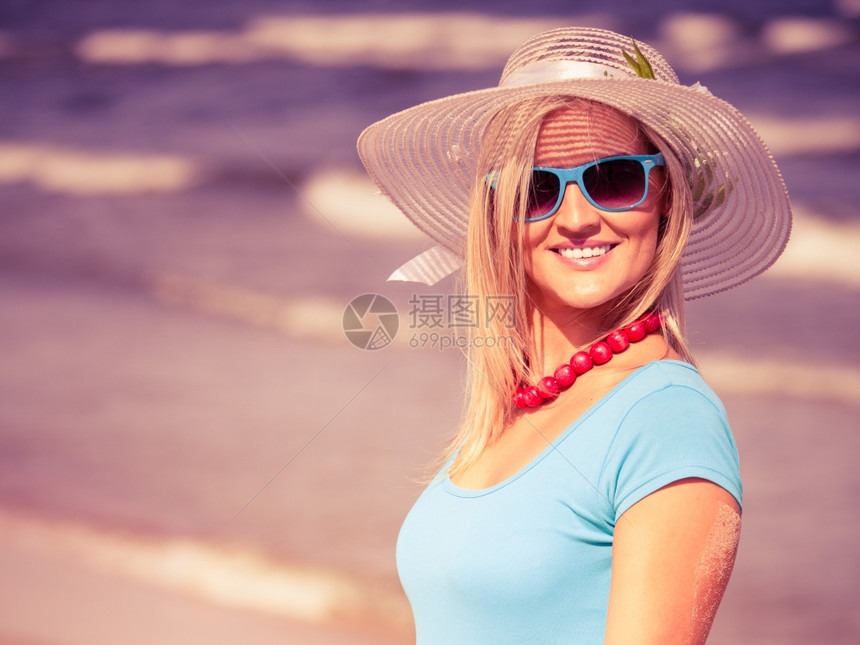 时装幸福和生活方式概念穿着帽子和彩色太阳眼镜的金发美女在海滩上行走年轻女子在海边放松图片