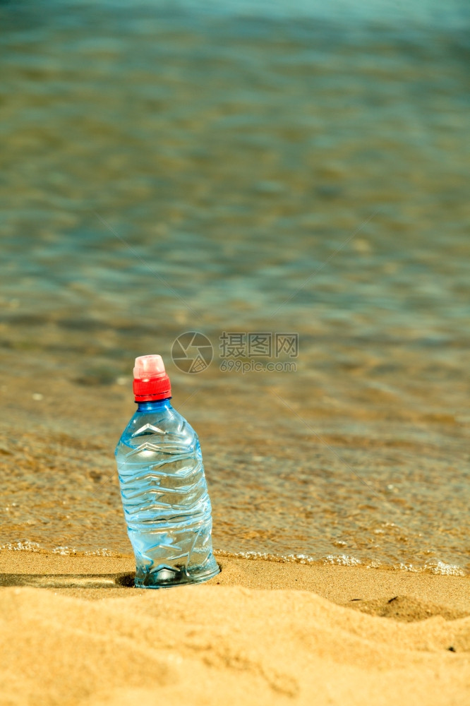 关闭沙滩上塑料水瓶饮图片