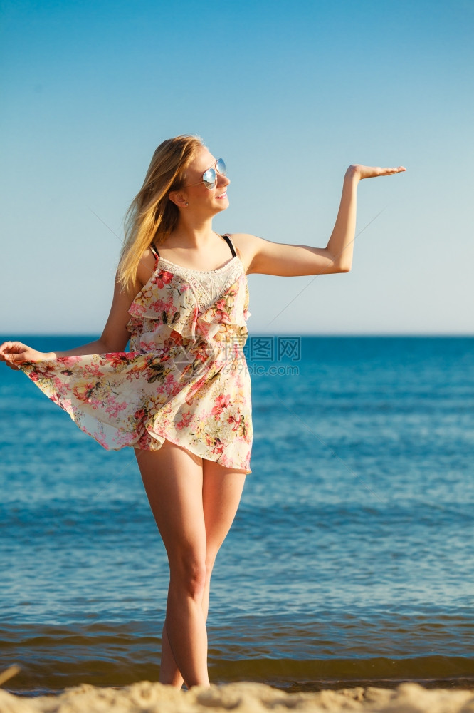 穿暑期服装的女孩在海滩上空手的间上年轻女人在海边放松夏天图片