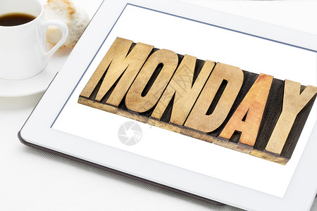 星期一在数字平板电脑上用纸质木头字加上一杯咖啡背景图片