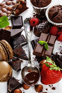 各种巧克力有坚果松饼马卡龙白色背景的巧克力图片