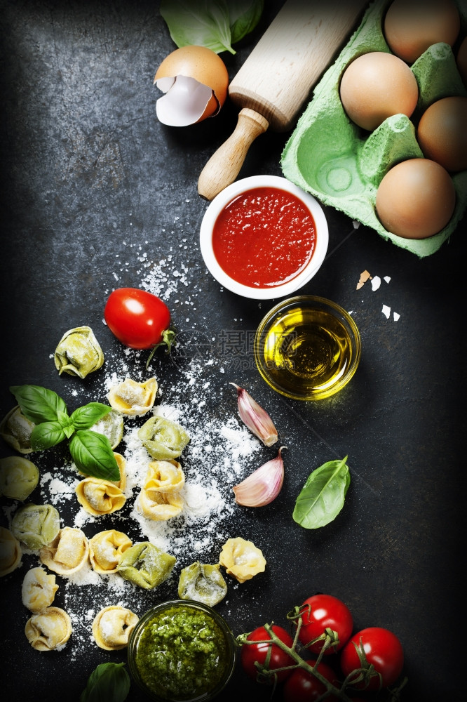 意大利自制生土为意大利托尔特尼有面粉和番茄的Basil叶和深色古年背景的西红柿图片