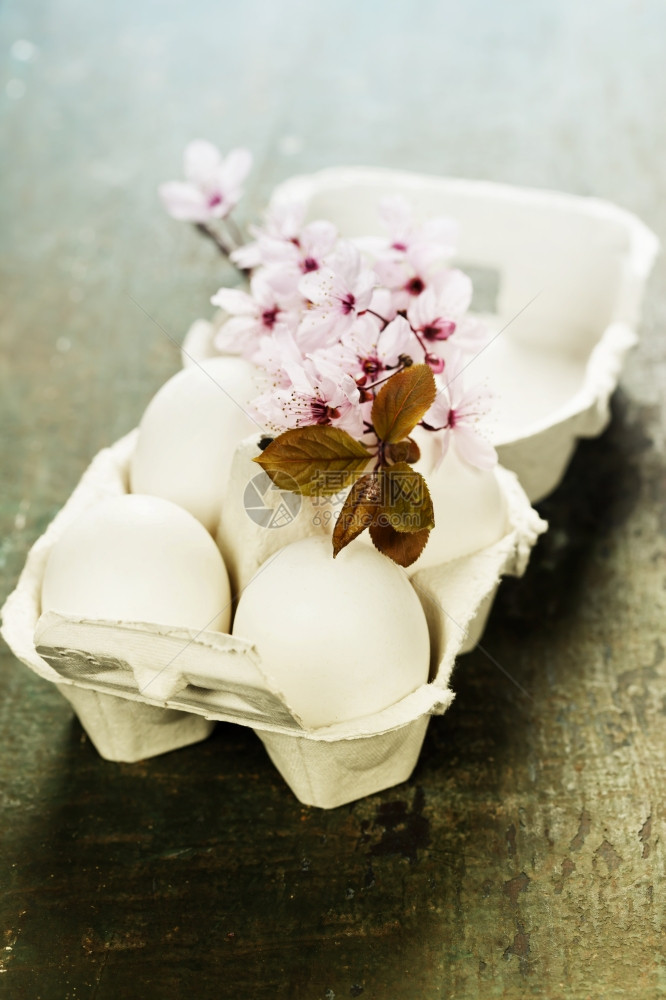 复活节鸡蛋和春樱花在木制桌上图片