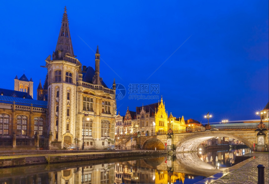 在比利时根特镇夜里莱河的QuayGrasleiQuayGraslei上拍摄中世纪建筑和邮宫图片