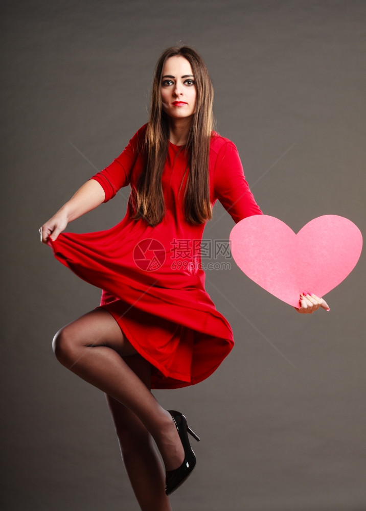 白发女人穿红裙子长发带着心爱的象征跳舞是黑暗的灰色背景图片