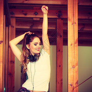 音乐和技术概念微笑着的少女穿白衬衫戴耳机的白衬衫听耳机在家里跳舞图片